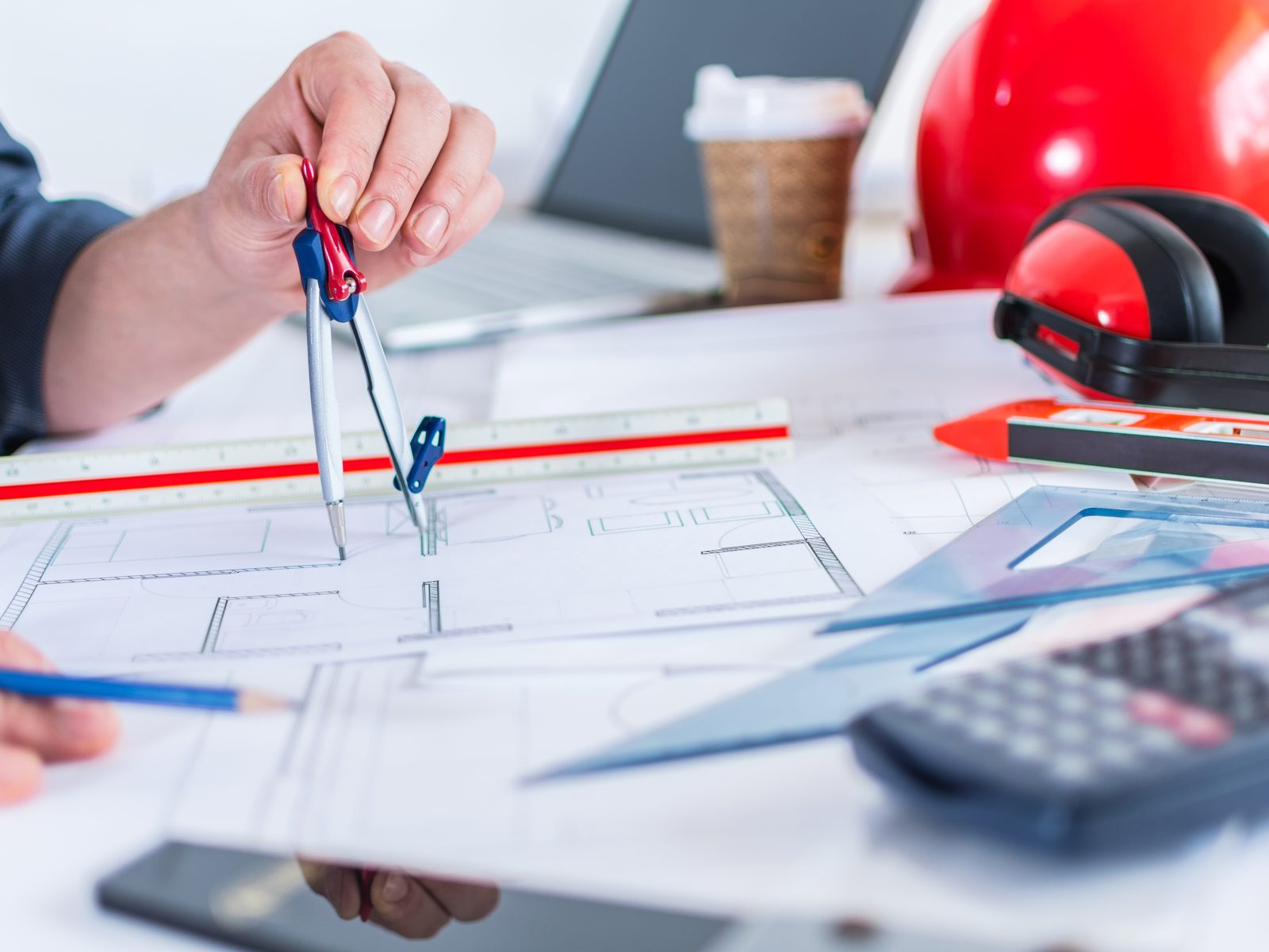 Drawing compasses and technical plans on a designer's desk